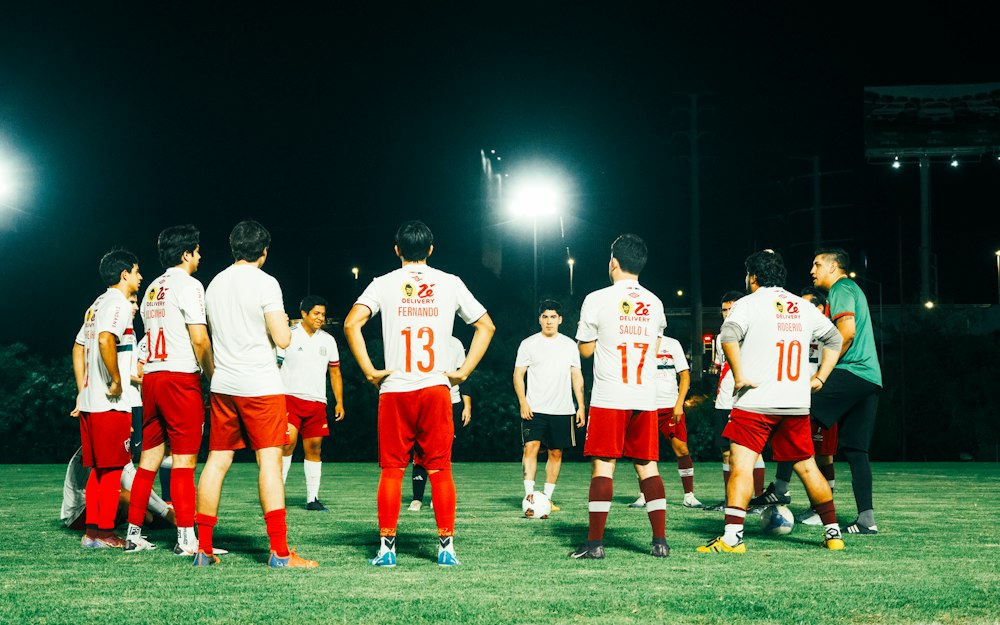 Squadra di calcio raccolta in campo di sera